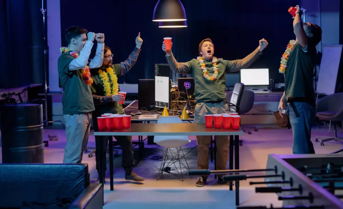 People cheering over a beer pong table